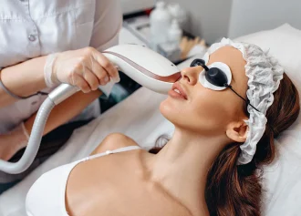close-up-picture-young-beautiful-girl-lies-white-couch-receives-therapeutic-spa-treatment-against-wrinkles-wearing-protective-hat-goggles-against-radiation